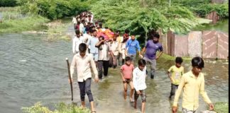घुटनों तक भरे बदबूदार पानी के बीच शव यात्रा निकालने को मजबूर भील समाजजन