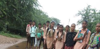 सड़क पर भरे हुए पानी से विद्यालय जाने को मजबूर विद्यार्थी